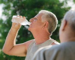 Seniors Drinking Water After Fitness In Park