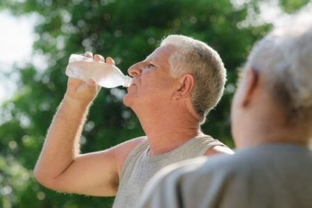 Seniors Drinking Water After Fitness In Park