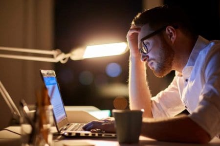 businessman typing on laptop at night office