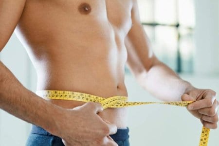 man-measuring-belly-and-waist-with-yellow-tape