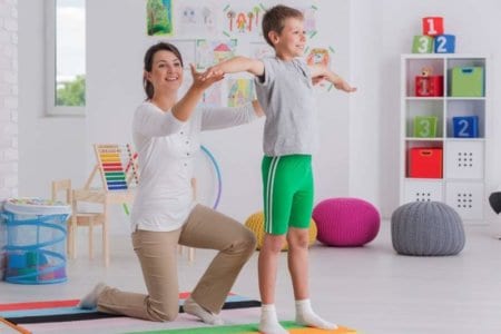 physiotherapist-exercising-with-a-school-boy