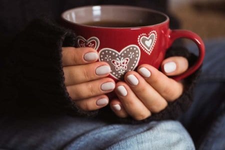 woman-with-beautiful-manicure-holding-a-red-cup