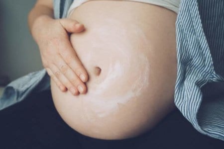 pregnant-woman-putting-cream-on-her-belly