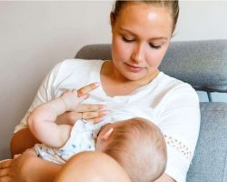 caring-young-mother-breastfeeds-baby-girl