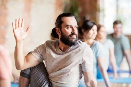 man-with-group-of-people-doing-yoga-at-studio