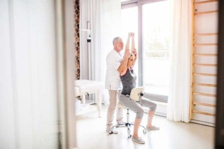 senior-male-physiotherapist-working-with-a-female