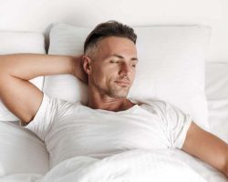 smiling-man-relaxing-in-bed