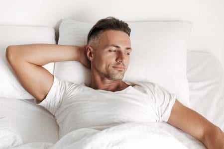 smiling-man-relaxing-in-bed