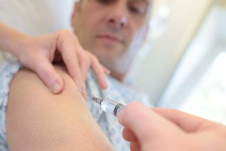 doctor-puts-syringe-in-male-arm