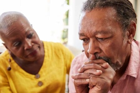 senior-woman-comforting-man-with-depression