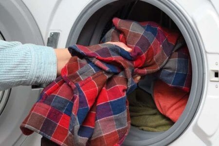 woman-puts-clothes-in-washing-machine