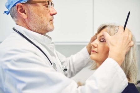 plastic-surgeon-holding-head-of-adult-woman