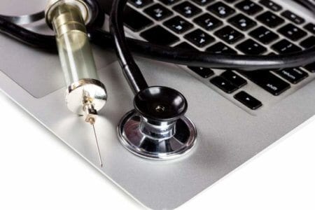 stethoscope-and-syringe-on-keyboard